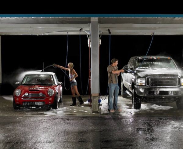 Two people cleaning their cars